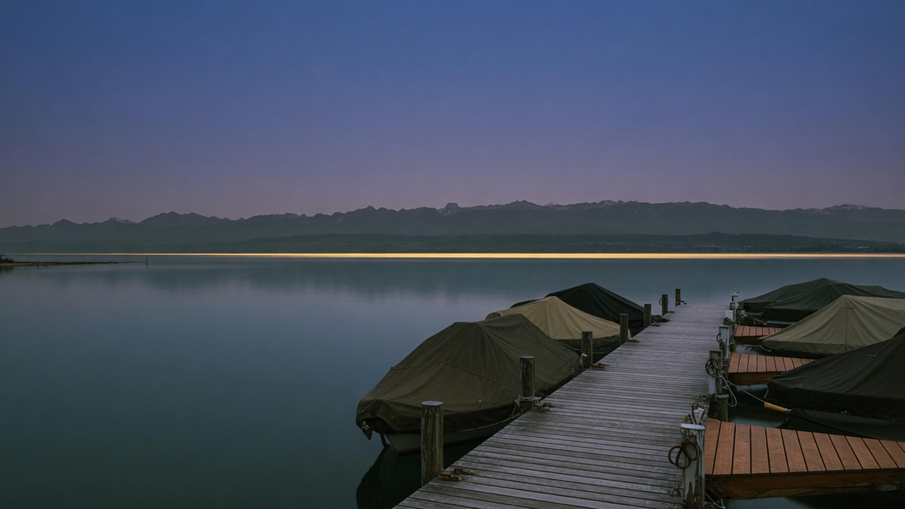 Bodensee am Abend, Blick von der Werft über Steg und stilles Wasser